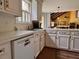 Bright kitchen with white cabinets, neutral countertops, and a view into the open living area beyond at 7 Lavington Rd, Charleston, SC 29407