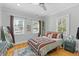 Bright bedroom featuring hardwood floors, three windows, and an overhead fan at 7 Wesley Dr, Charleston, SC 29407