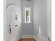 Entryway features a charming arched door, transom window, light walls, and light hardwood flooring at 7 Wesley Dr, Charleston, SC 29407