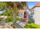 Charming home featuring a turret entrance with a red door, complemented by a mature palm tree and tidy landscaping at 7 Wesley Dr, Charleston, SC 29407