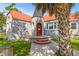 Charming home with a unique turret entrance, red door, orange roof, gray brick, and mature palm tree at 7 Wesley Dr, Charleston, SC 29407