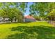 Spacious front lawn featuring mature trees and a charming home with a red roof at 7 Wesley Dr, Charleston, SC 29407