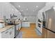 Bright kitchen with granite countertops, white cabinets, stainless steel appliances, and hardwood floors at 7 Wesley Dr, Charleston, SC 29407