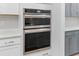 Stainless steel double ovens integrated into white cabinets with white tile backsplash and countertops at 727 Hodge Rd, Summerville, SC 29483