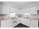 Well-lit kitchen with white cabinets, a range, and a double basin sink at 7813 Sandida Ct, North Charleston, SC 29418