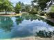 Scenic pond reflecting the surrounding trees and buildings, creating a serene and picturesque atmosphere at 7813 Sandida Ct, North Charleston, SC 29418