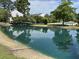 Tranquil pond with a charming bridge, complemented by lush trees and community amenities in the background at 7813 Sandida Ct, North Charleston, SC 29418
