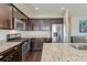 Modern kitchen with stainless steel appliances, granite countertops, and dark wood cabinets at 8038 Regency Elm Dr, North Charleston, SC 29406