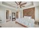 Large bedroom featuring a tray ceiling, ceiling fan, and ensuite bathroom with a walk-in closet at 8038 Regency Elm Dr, North Charleston, SC 29406