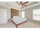 Spacious bedroom with tray ceiling, ceiling fan, decorative wood headboard, and lots of natural light at 8038 Regency Elm Dr, North Charleston, SC 29406