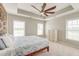 Bright bedroom boasts neutral paint, tray ceilings, ceiling fan, and a view of the outdoors at 8038 Regency Elm Dr, North Charleston, SC 29406