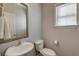 Powder room with a pedestal sink, decorative mirror, and a window allowing natural light at 8038 Regency Elm Dr, North Charleston, SC 29406