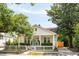 Charming white cottage with a picket fence and lush landscaping, showcasing classic curb appeal at 814 Rutledge Ave, Charleston, SC 29403