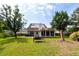 View of backyard with lawn, trees, swing and exterior of house featuring a sunroom and solar panels at 8522 Long Meadow Dr, Charleston, SC 29420