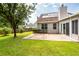 View of backyard lawn and patio; exterior of house with sunroom and solar panels at 8522 Long Meadow Dr, Charleston, SC 29420