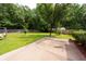 Spacious backyard with lush lawn, mature trees, and a concrete patio at 8522 Long Meadow Dr, Charleston, SC 29420
