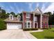 Charming two-story brick home featuring a two-car garage, red shutters, and beautiful landscaping at 8522 Long Meadow Dr, Charleston, SC 29420