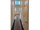 Hallway with decorative carpet runner and view to entry door with sidelights at 8522 Long Meadow Dr, Charleston, SC 29420