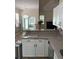 Kitchen area featuring granite countertops, white cabinetry, and views to the sunroom and breakfast area at 8522 Long Meadow Dr, Charleston, SC 29420