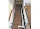 Carpeted stairway with wooden railings and installed stair lift at 8522 Long Meadow Dr, Charleston, SC 29420