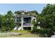 Modern waterfront home with lush greenery, multi-level balconies, and private dock access at 905 Palm Blvd, Isle of Palms, SC 29451