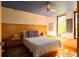 Serene main bedroom featuring a ceiling fan, sleek wood paneling and abundant natural light at 905 Palm Blvd, Isle of Palms, SC 29451