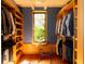 Sunlit walk-in closet featuring custom wood shelving, natural light, and modern chair at 905 Palm Blvd, Isle of Palms, SC 29451