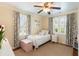 Cozy bedroom with a twin bed, shuttered windows, and bright colorful curtains with pictures of butterflies on the wall at 95 Gordon St, Charleston, SC 29403