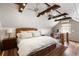 Large main bedroom with exposed wooden beams, a wicker bed frame, wood floors and desk with computer setup at 95 Gordon St, Charleston, SC 29403