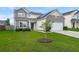 Two-story home features manicured lawn, neutral siding, stone accents, and attached two-car garage at 9711 Tackle St, Ladson, SC 29456