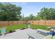Spacious backyard with lawn, wooden fence, concrete patio, and lounge chairs at 1004 Saltwater Cir, Johns Island, SC 29455