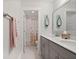 Bright bathroom featuring a double sink vanity with gray cabinets and a shower-tub combo with decorative curtain at 1004 Saltwater Cir, Johns Island, SC 29455