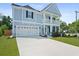 Charming two-story home featuring a light blue facade, inviting front porch, and well-manicured lawn at 1004 Saltwater Cir, Johns Island, SC 29455