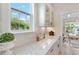 Stylish butler's pantry with white cabinetry, stone countertops, herringbone backsplash, and a bright window at 1004 Saltwater Cir, Johns Island, SC 29455