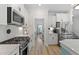 Modern white kitchen featuring stainless steel appliances, quartz countertops, and herringbone backsplash at 1004 Saltwater Cir, Johns Island, SC 29455