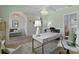 Bright office with stylish desk, piano, chandelier, and calming sage green walls at 1004 Saltwater Cir, Johns Island, SC 29455