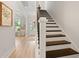 Bright foyer with staircase featuring hardwood treads and a view to the light-filled office and front door at 1004 Saltwater Cir, Johns Island, SC 29455