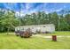 Spacious yard with parking area showcasing a single-story home nestled among lush trees under a bright, open sky at 1051 Cooper Store Rd, Moncks Corner, SC 29461