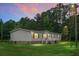 Charming single-story home with vinyl siding, a brick foundation, and a welcoming front porch under a colorful dusk sky at 1051 Cooper Store Rd, Moncks Corner, SC 29461