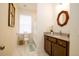 Well-lit bathroom featuring a decorative mirror, granite countertop, and tiled floors, offering a blend of style and comfort at 1076 Hatfield St, North Charleston, SC 29405