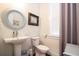 Bright powder room featuring a pedestal sink, decorative mirror and a window with shades, providing a fresh and clean space at 1076 Hatfield St, North Charleston, SC 29405