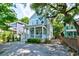 Beautiful two-story home featuring lush landscaping, a gravel driveway, and a cozy front porch at 1076 Hatfield St, North Charleston, SC 29405