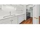 Well-equipped kitchen with sleek white cabinetry and stainless steel sink, attached laundry room at 108 Woodlake Dr, Summerville, SC 29485