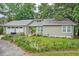 Charming home showcasing a metal roof, green siding, inviting front yard, and an attached two-car garage at 109 Willow Ct, Summerville, SC 29486
