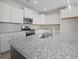 Open kitchen featuring hardwood floors, kitchen island, granite countertops, and white cabinets at 112 Shingle Oak Dr, Moncks Corner, SC 29461