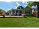 Well-maintained backyard with artificial turf, a brick patio, and a comfortable screened-in porch at 1231 Wild Olive Dr, Mount Pleasant, SC 29464