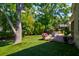 Inviting backyard with artificial grass, a brick patio, shade trees and charming privacy fence at 1231 Wild Olive Dr, Mount Pleasant, SC 29464