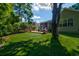 Beautiful backyard with artificial turf, brick patio, and mature shade trees for outdoor enjoyment at 1231 Wild Olive Dr, Mount Pleasant, SC 29464