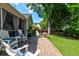 Relaxing backyard brick patio with Adirondack chairs, a screened porch, and well-manicured lawn at 1231 Wild Olive Dr, Mount Pleasant, SC 29464