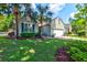 Charming single-story home with a well-manicured lawn, palm trees, and an attached two-car garage at 1231 Wild Olive Dr, Mount Pleasant, SC 29464